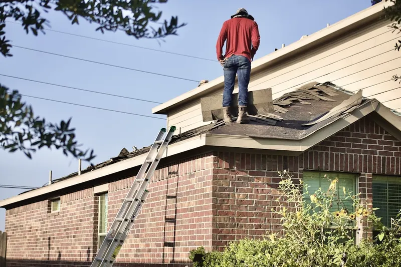 Professional roofer working on a residential roof in Highlands Park